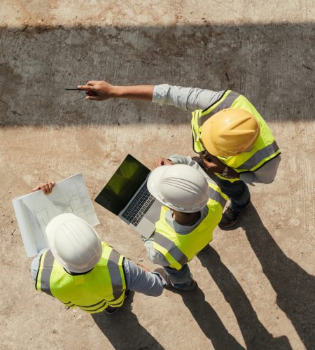 Top view, Team engineer building inspection use tablet computer and blueprint working at construction site. Civil Engineer, Contractor and Architect discussing in construction site.